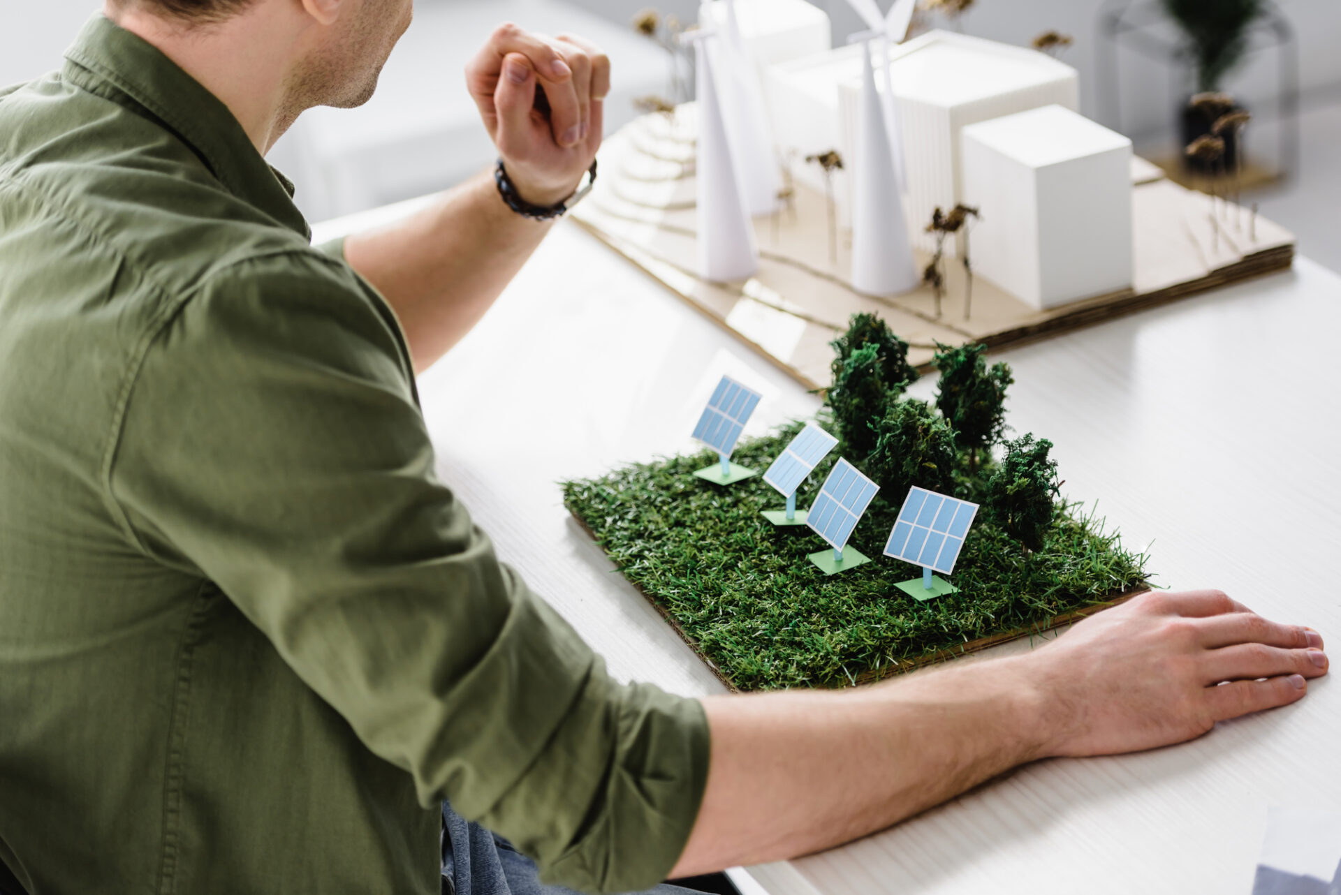 man sitting in front of models of buildings trying to decide the best solar panel